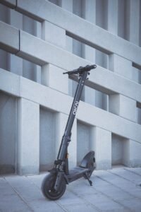 black and gray bicycle leaning on white concrete wall