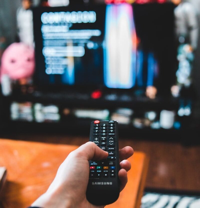 person holding black remote control, kaukosäädin, TV