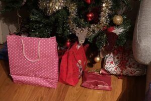 Joululahjoja paketissa kuusen alla, odottamassa kierrätystä